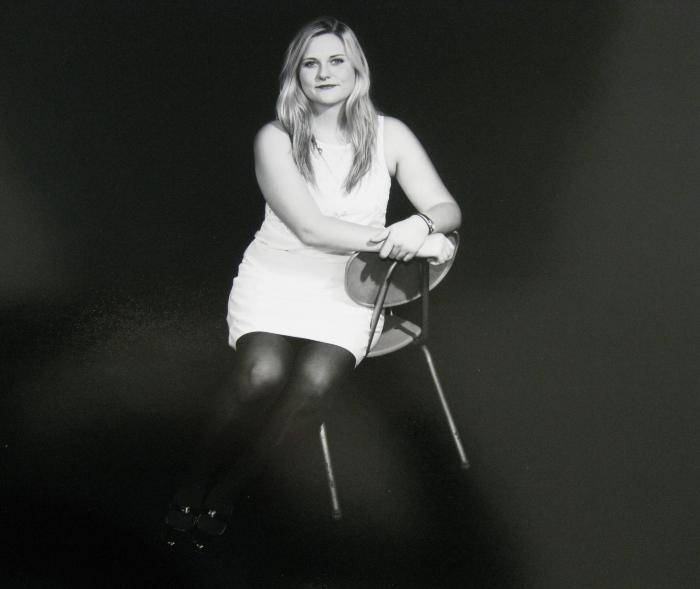 Photograph of a person in white dress on black background